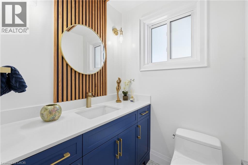 Half bath with vanity and wallpapered walls