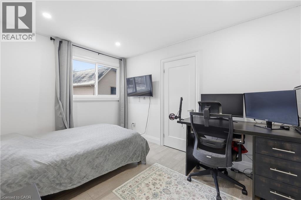 Bedroom with a desk, light wood-style flooring, and recessed lighting