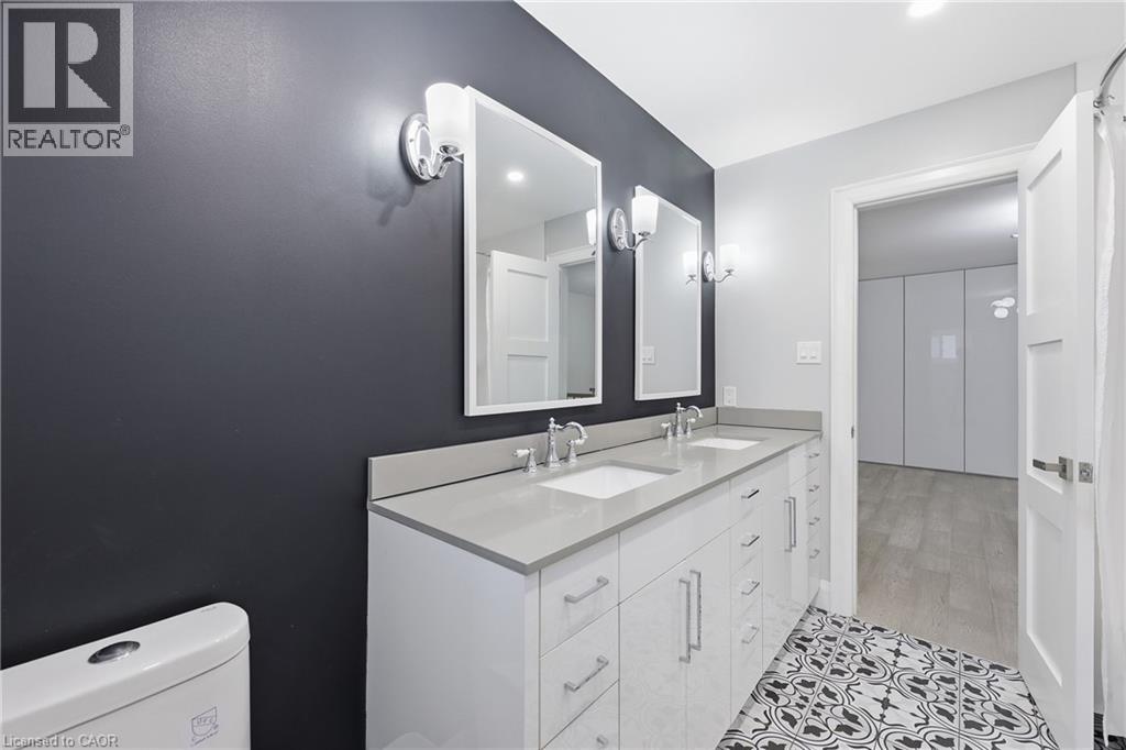 Bathroom with double vanity and light tile patterned floors