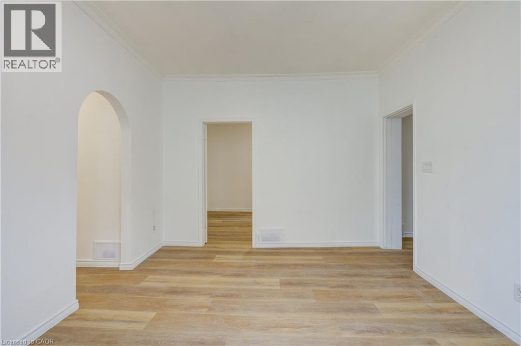 This room features light-colored flooring, white walls, and an arched doorway