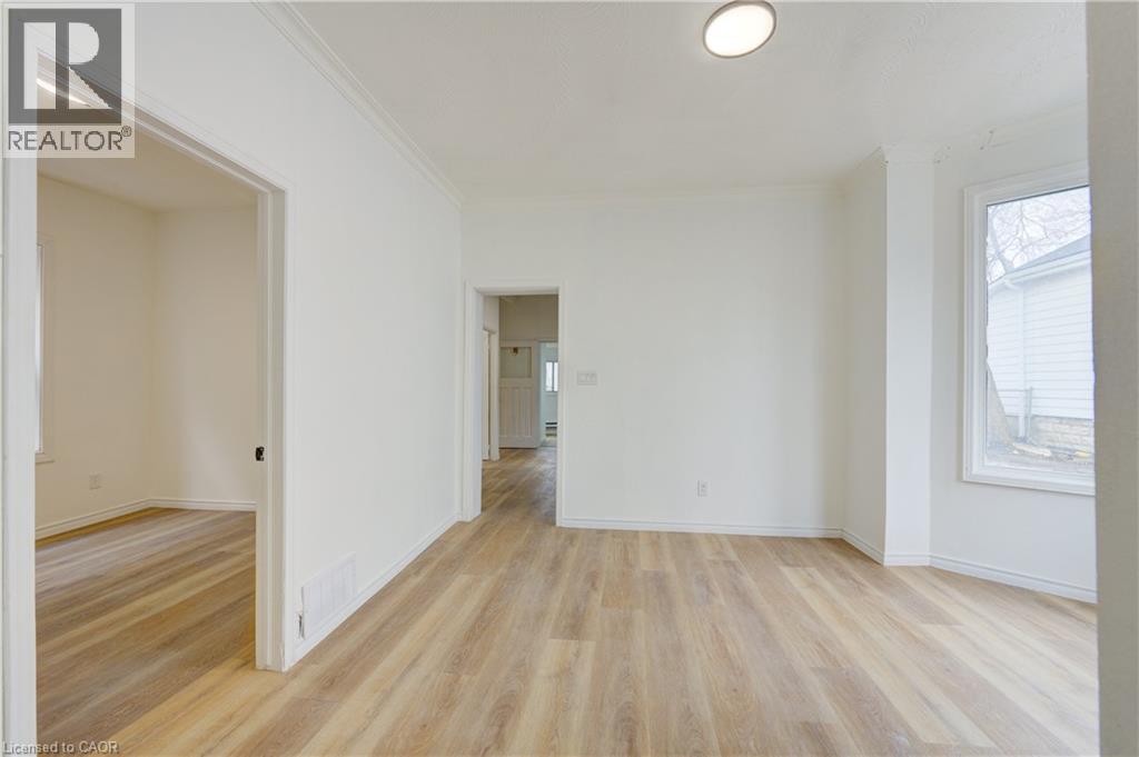 Bright interior space featuring light-toned flooring, white walls, and a ceiling light fixture
