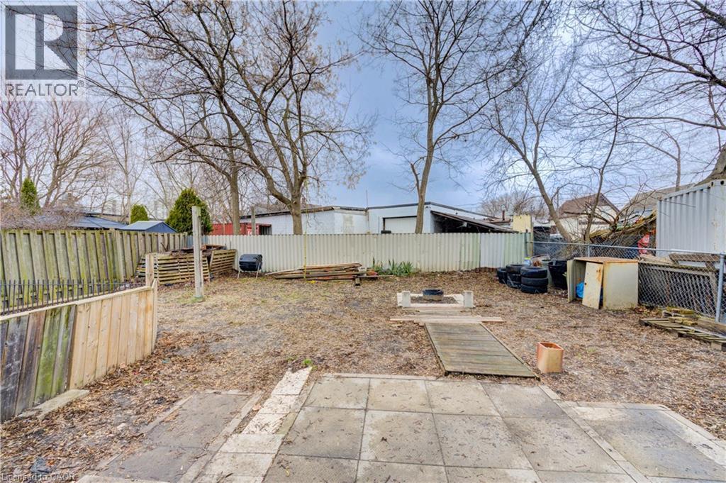 The property features a fenced yard with a concrete patio area and mature trees