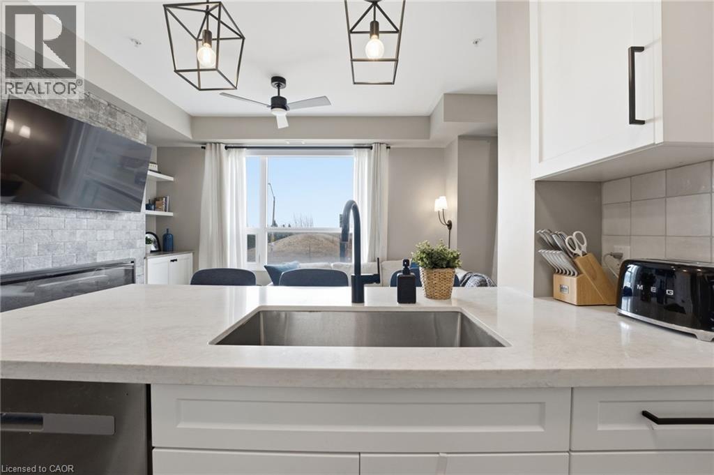 Kitchen featuring backsplash, white cabinetry, light stone countertops, ceiling fan, and dishwasher