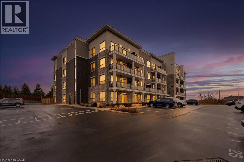 Property at dusk with a view of apartment building / complex and uncovered parking