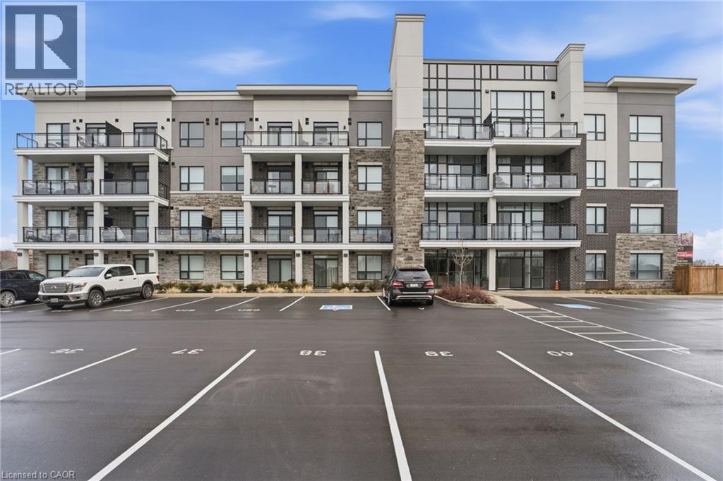 View of apartment building / complex featuring uncovered parking