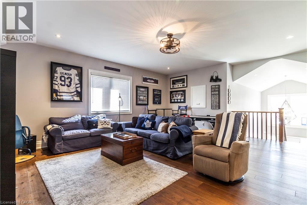 Living room with hardwood / wood-style flooring, lofted ceiling, and recessed lighting