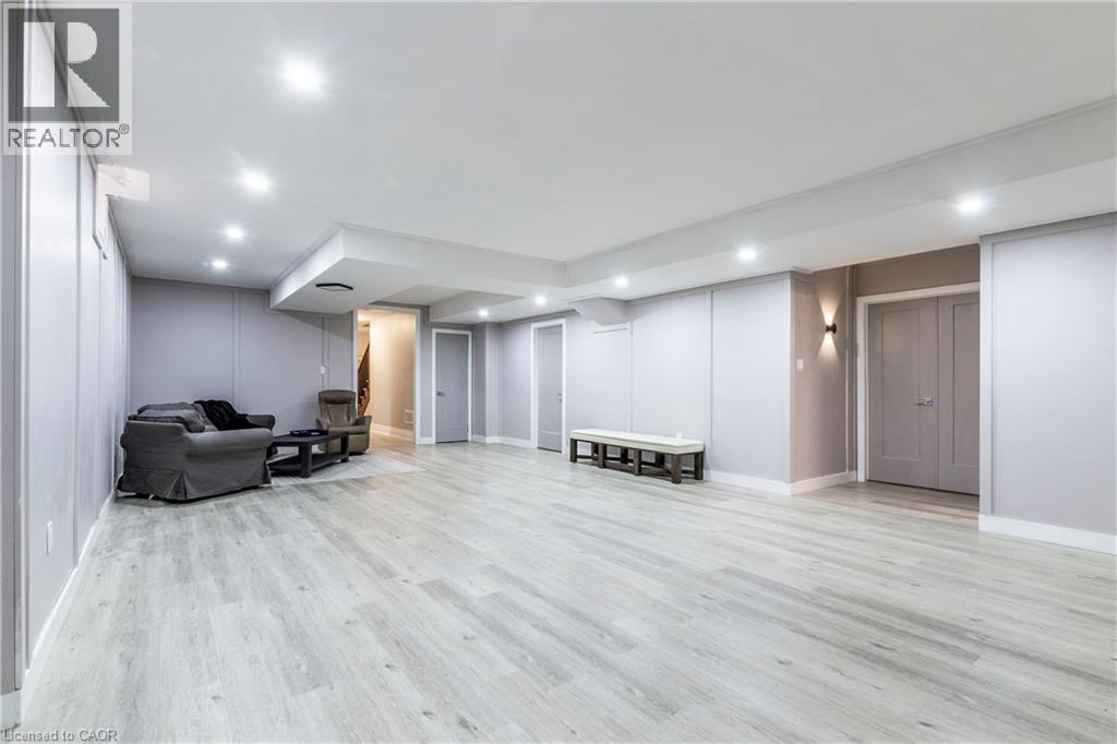 Finished basement with light wood finished floors and recessed lighting