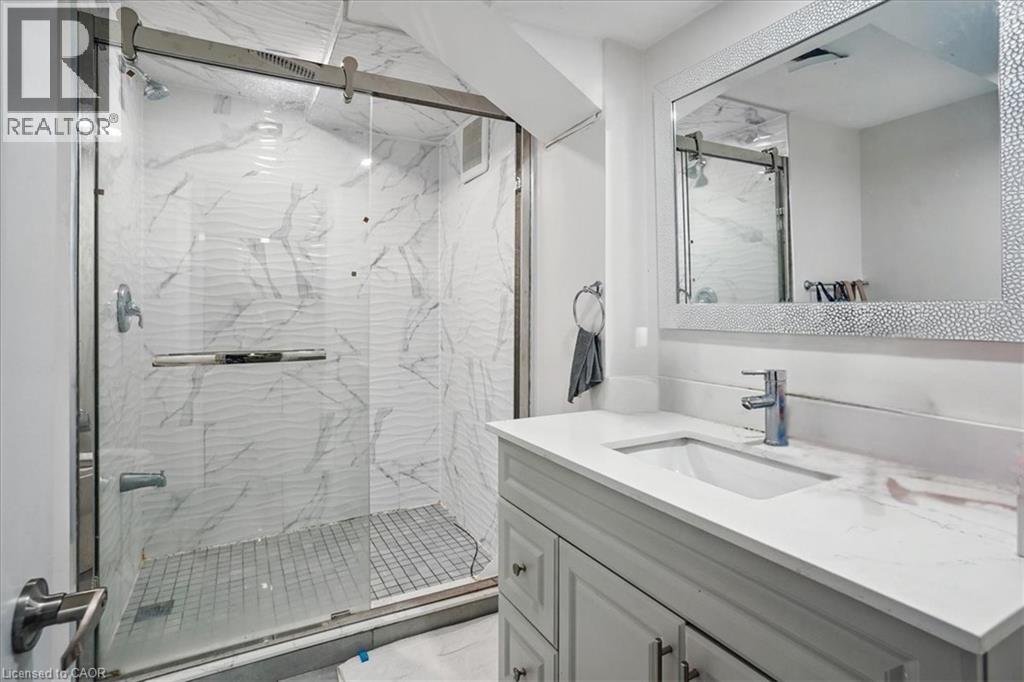 Bathroom with vanity and a marble finish shower