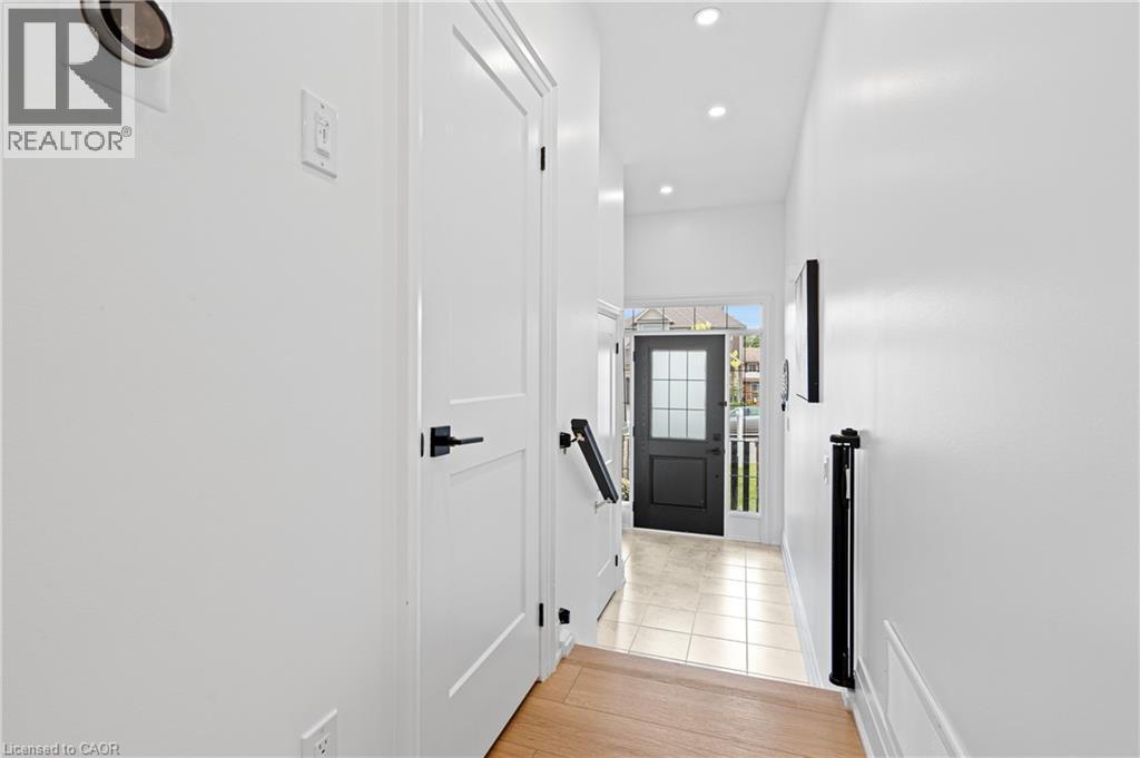 Bright entryway featuring a dark-paneled door with glass inserts, recessed lighting, and tile flooring