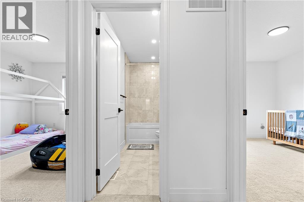 Hallway bathroom featuring a white soaking tub, tiled shower surround, and recessed lighting