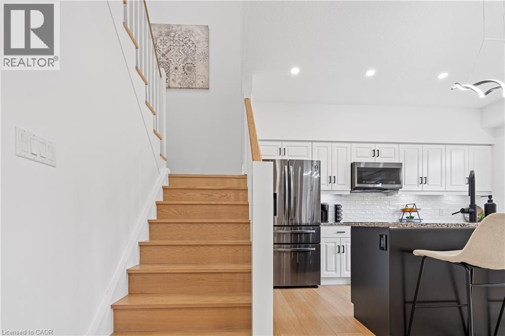 Natural wood-finish staircase with white risers and railing, complementing the light wood-finish flooring