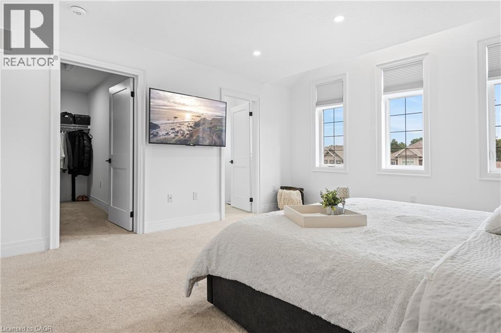 Carpeted bedroom with three windows featuring horizontal blinds