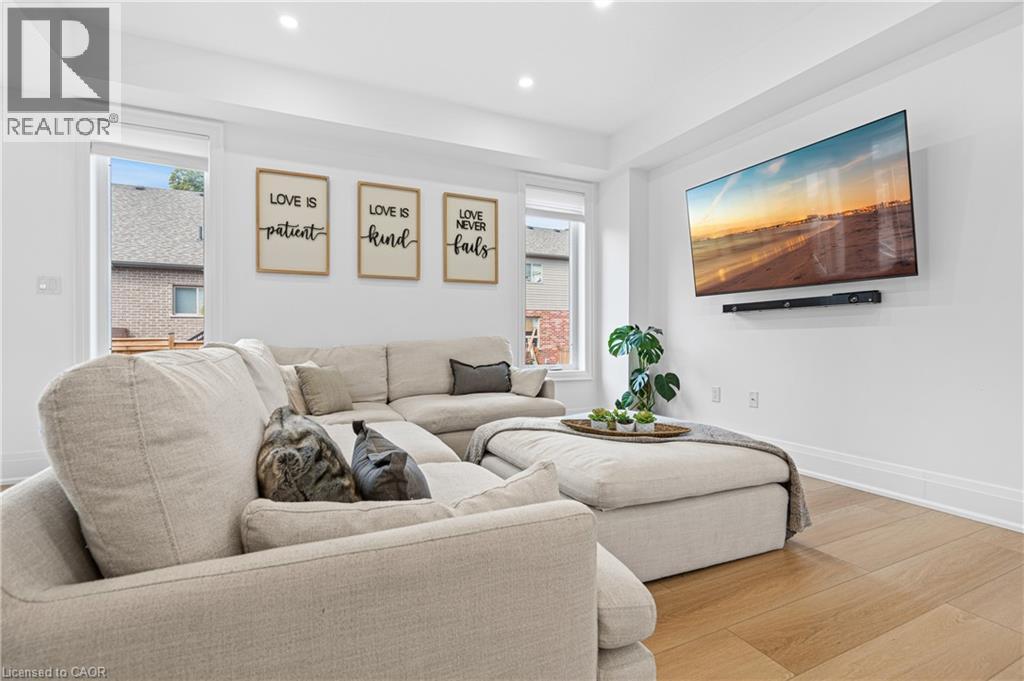 Bright living area featuring wood-finish flooring, recessed lighting, and crisp white walls