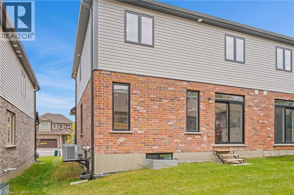 Brick and siding exterior featuring multiple windows and sliding glass doors