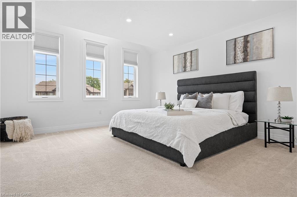 Bright room featuring three tall windows with white frames and blinds, recessed lighting, neutral tone carpet, and white baseboards