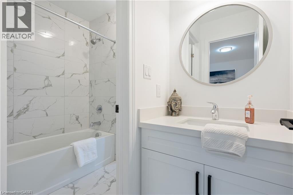 Bathroom featuring vanity and a combined bath / shower with marble appearance