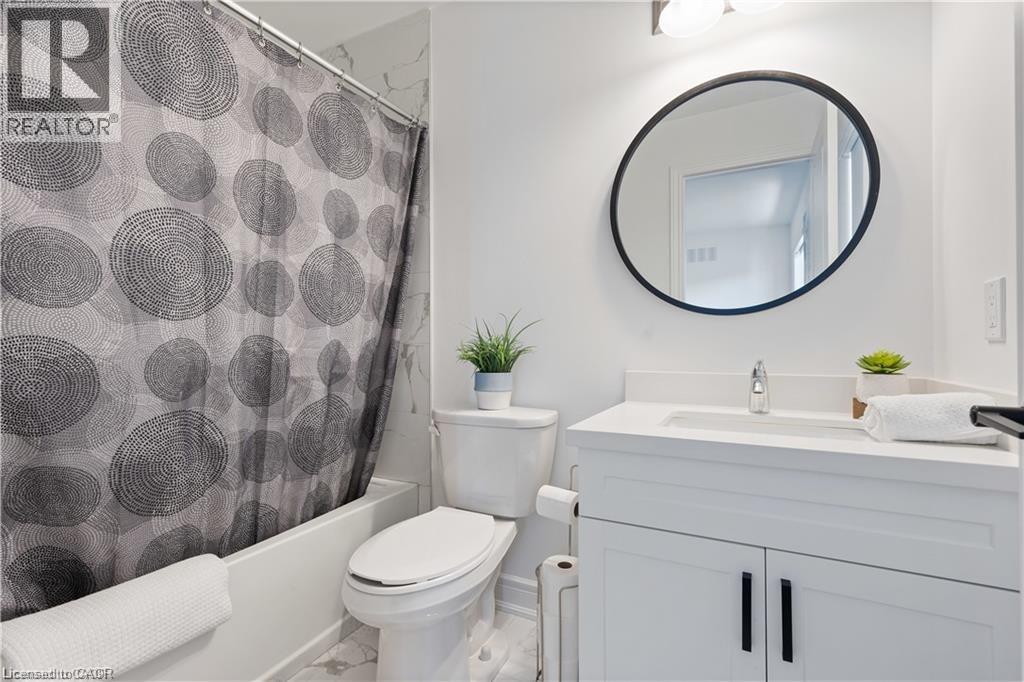 Bathroom featuring vanity and shower / bathtub combination with curtain