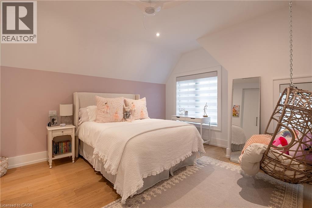 Bedroom featuring wood-finish flooring, a pitched ceiling, recessed lighting, and a window with blinds