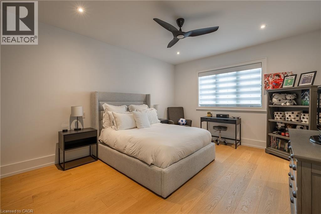 Light wood-finish flooring complements a window with horizontal blinds and a recessed ceiling with integrated lighting