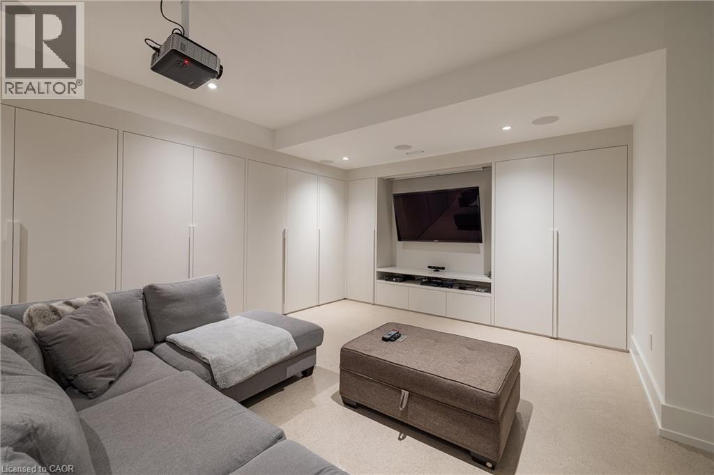 Integrated entertainment area featuring built-in cabinetry, a ceiling-mounted projector, recessed lighting, and carpet flooring