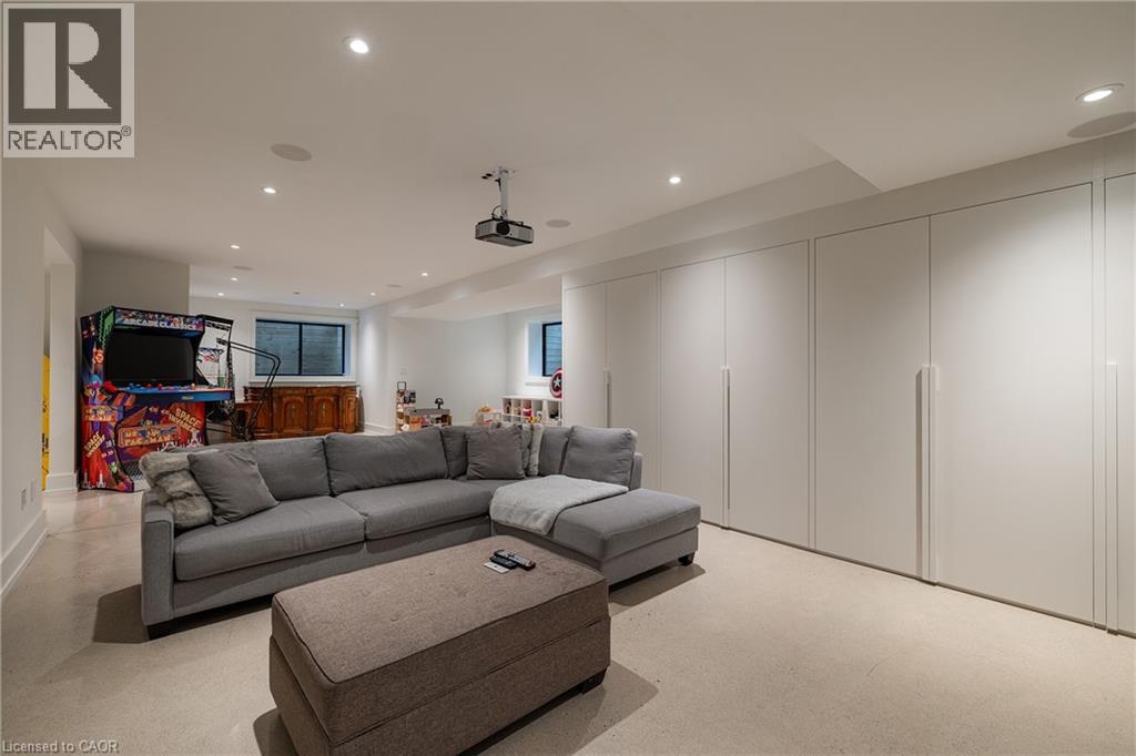 Lower level featuring recessed lighting, extensive built-in cabinetry, dual egress windows, and a ceiling-mounted projector