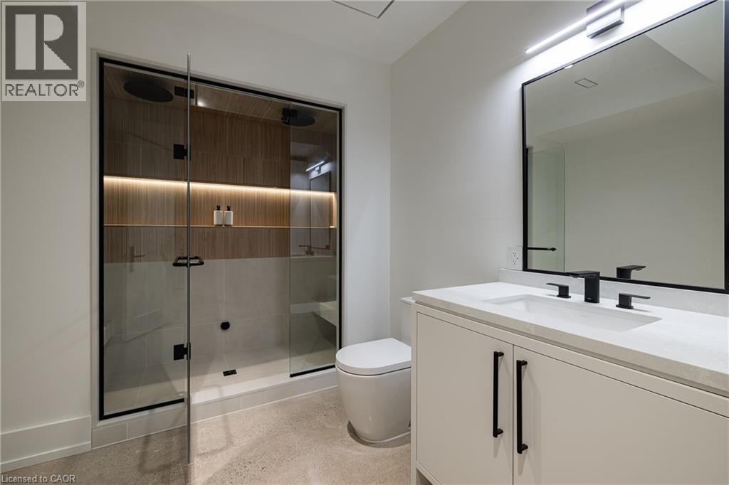 Contemporary bathroom featuring a spacious glass-enclosed shower with wood-finish paneling and integrated lighting