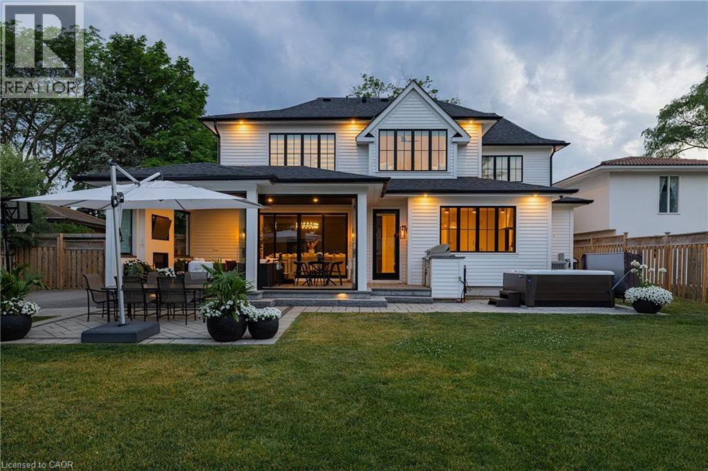 Rear exterior featuring white horizontal siding and black-framed windows
