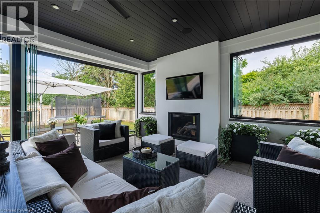 Covered outdoor living space featuring a black slatted ceiling with recessed lighting and a ceiling fan