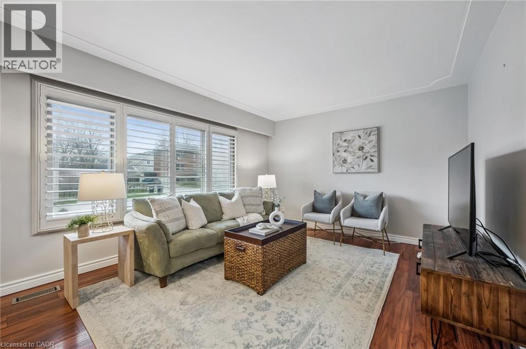 Living area featuring wood-finish flooring, crown molding, and neutral wall tones