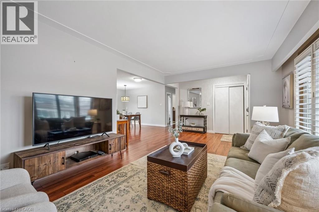 Living area featuring wood-finish flooring, plantation shutters, and a neutral color palette