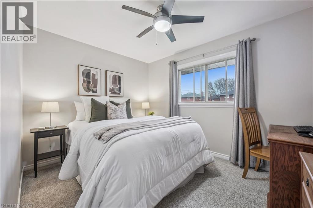 Carpeted room featuring a ceiling fan with integrated lighting, a window with curtains, and light gray painted walls