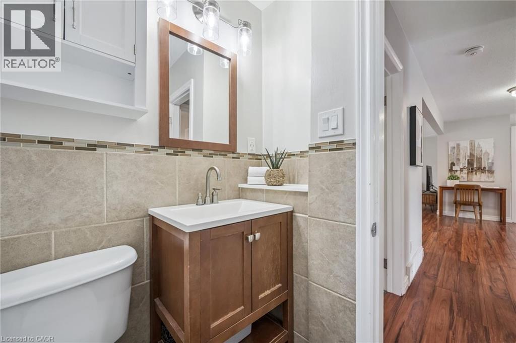 Bathroom featuring a wood-finish vanity with an integrated sink, a large wood-framed mirror, and chrome fixtures