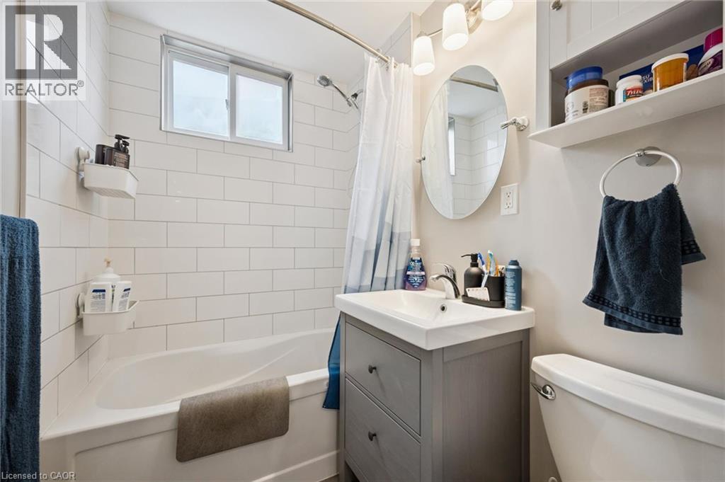 Bathroom featuring a white subway tile surround, a built-in bathtub, and a window for natural light