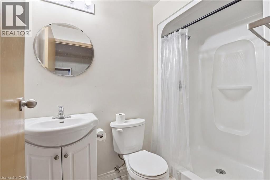 Bathroom featuring a white vanity with integrated sink, chrome faucet, and a wall-mounted circular mirror