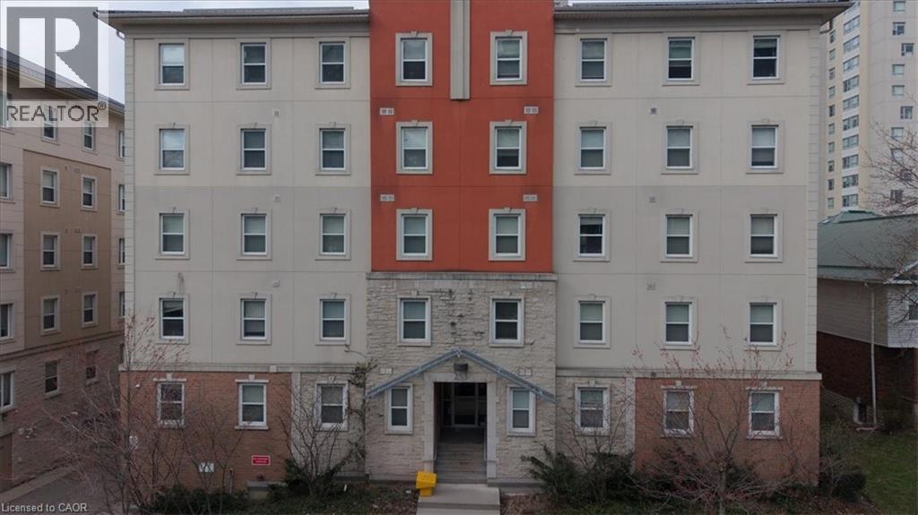 Multi-story building featuring a brick base, stone facade, and stucco exterior with contrasting red and beige sections