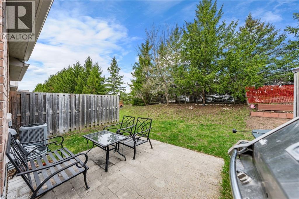 Private backyard featuring a paver patio area, a wooden privacy fence, and mature evergreen trees