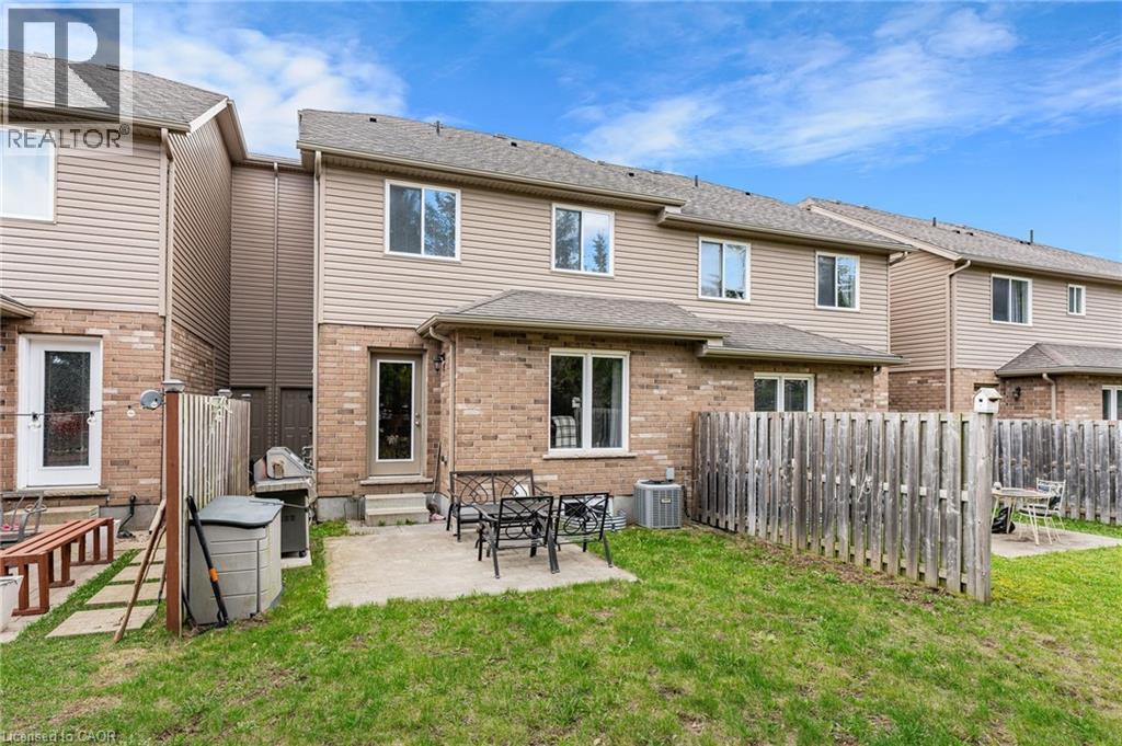 Private backyard featuring a concrete patio, green lawn, and wood privacy fencing
