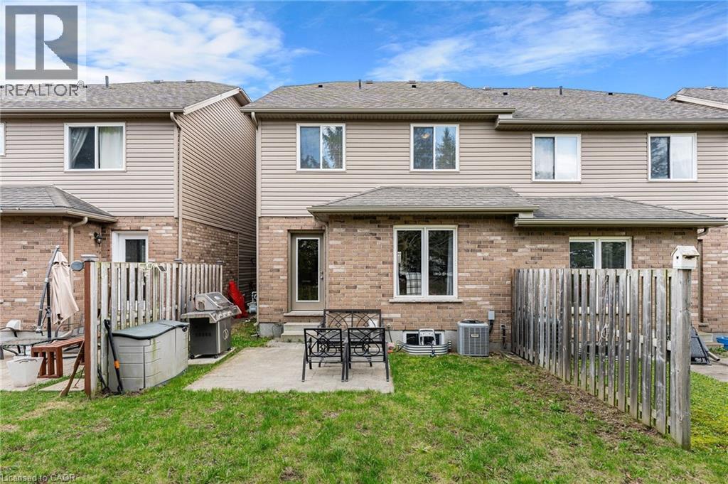 Expansive backyard featuring a manicured lawn, concrete patio, and privacy fencing