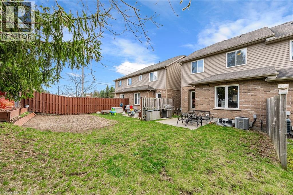 Expansive backyard featuring a partial grass lawn, a dedicated garden bed, and a full privacy fence
