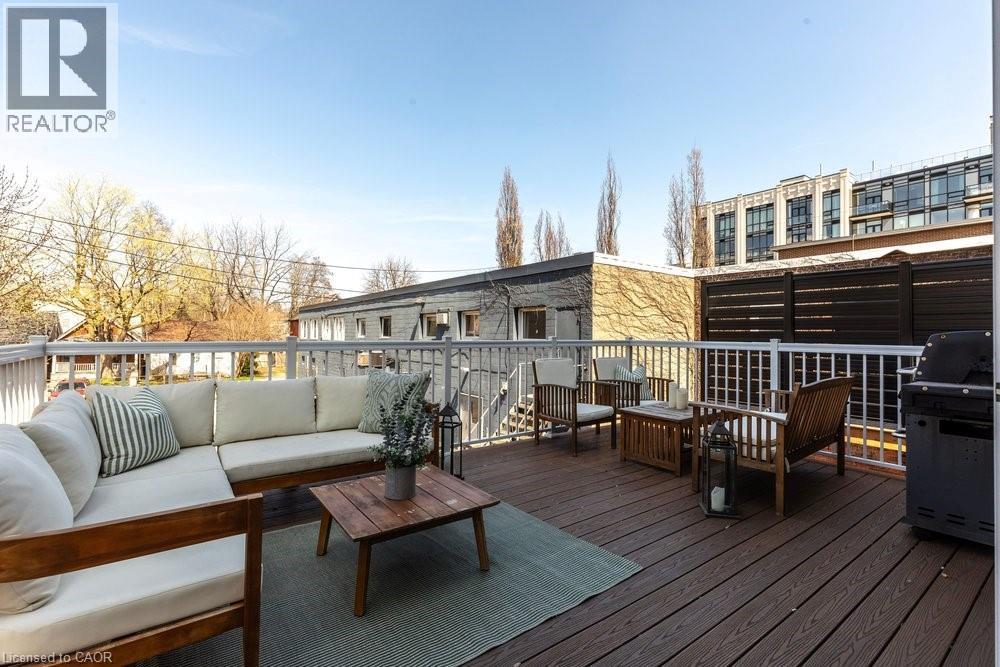 Spacious outdoor deck featuring composite decking, white railing, privacy screen, and exterior lighting