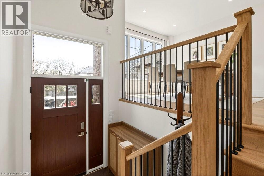 Entryway featuring a wood-panel door with glass inserts, a transom window, and a sidelight
