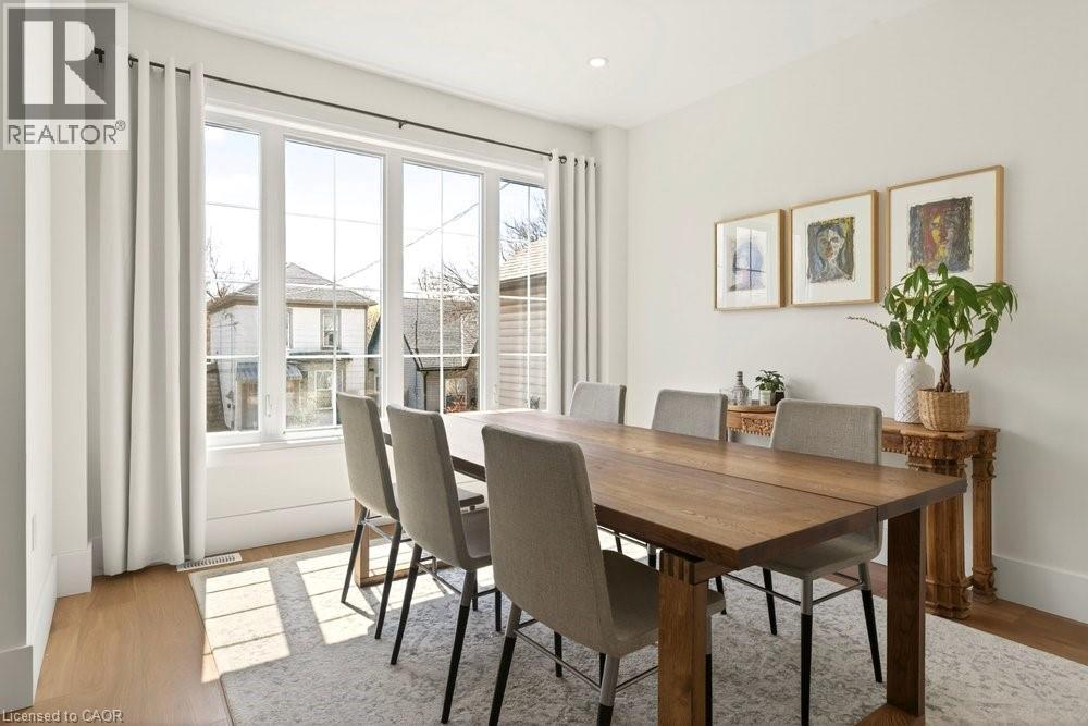 Dining area with expansive multi-pane windows, wood-finish flooring, recessed ceiling lighting, and crisp white walls