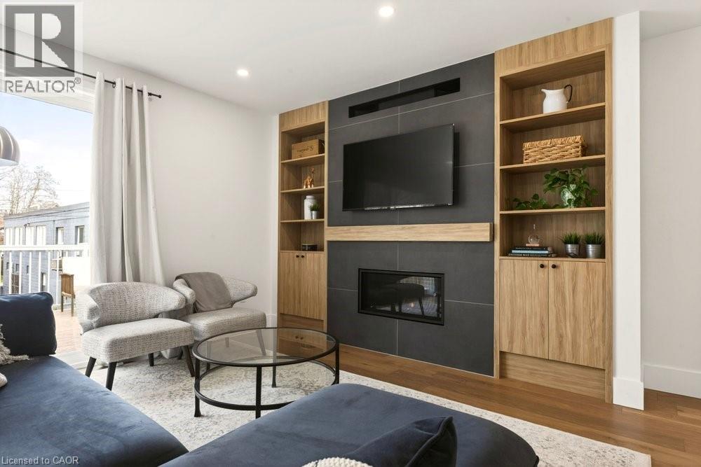 Living space featuring a tile-surround fireplace with a wood-finish mantel and integrated television mount