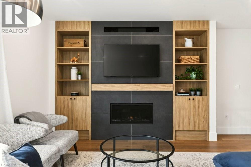 Built-in media center featuring a dark tile surround fireplace with a wood mantel