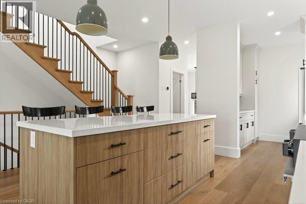 Kitchen island featuring a light wood-finish base, white countertop, and dark hardware