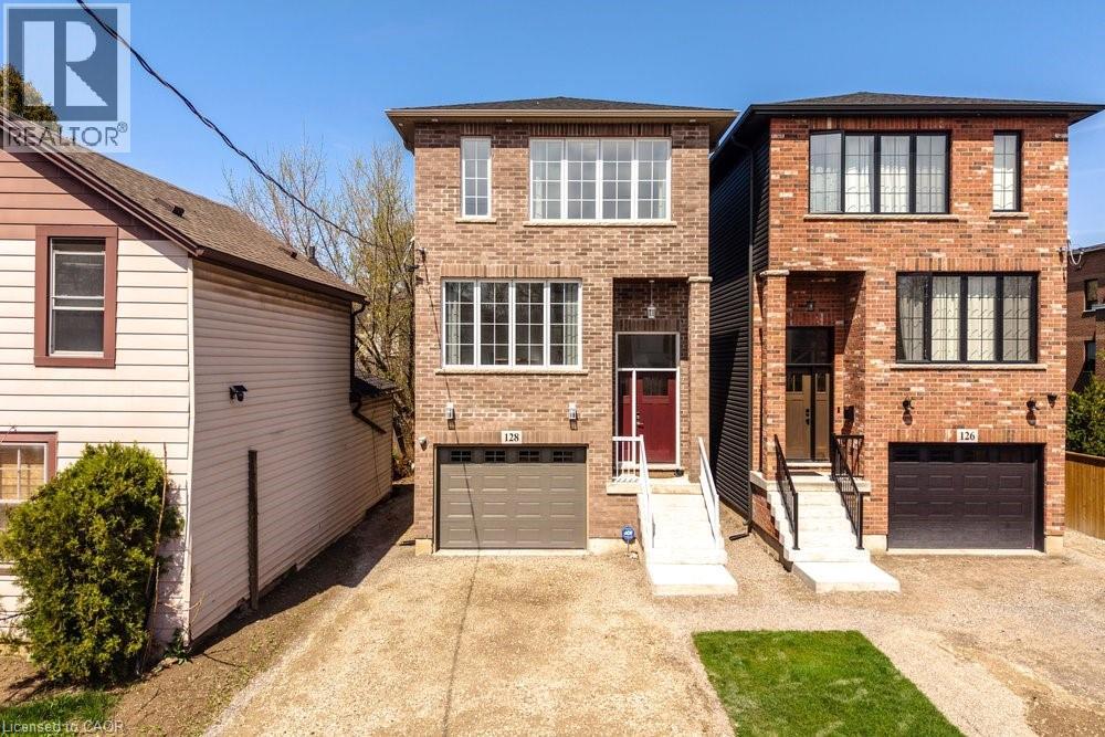 Brick facade home featuring a single garage, a red front door, white trimmed windows, and a paved driveway