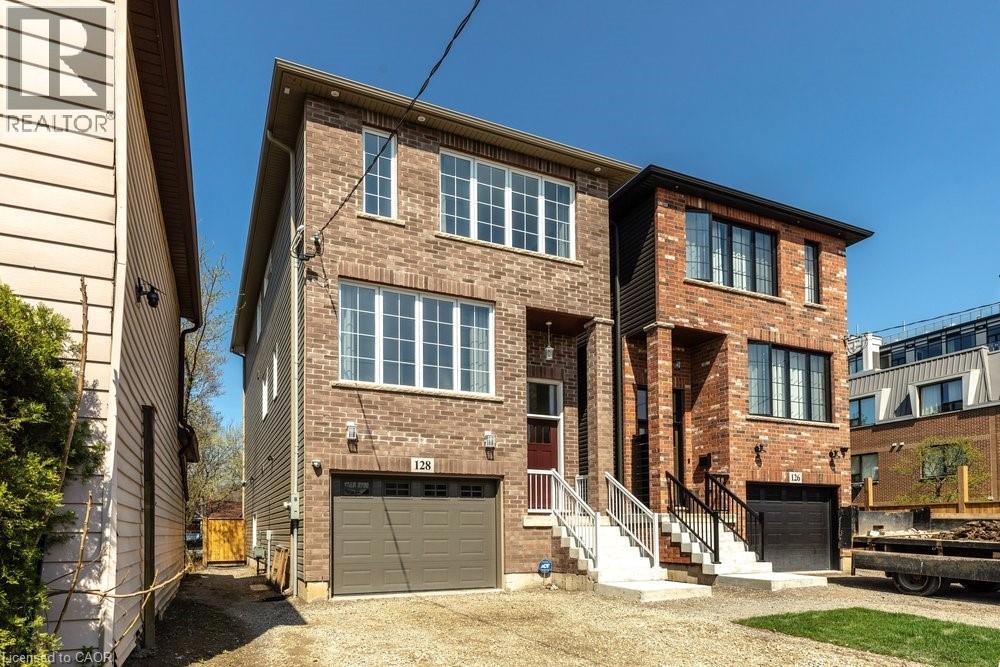 Brick exterior with contrasting trim, multiple windows across two levels, an integrated garage, and a covered entryway