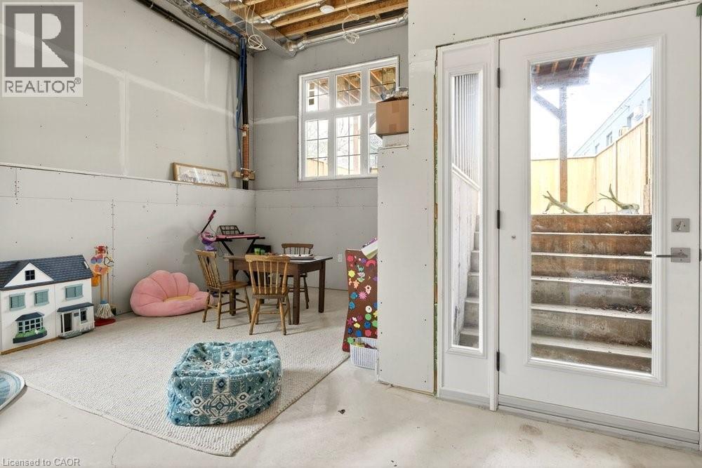 Unfinished lower level featuring drywall, exposed ceiling joists, and a partial concrete floor