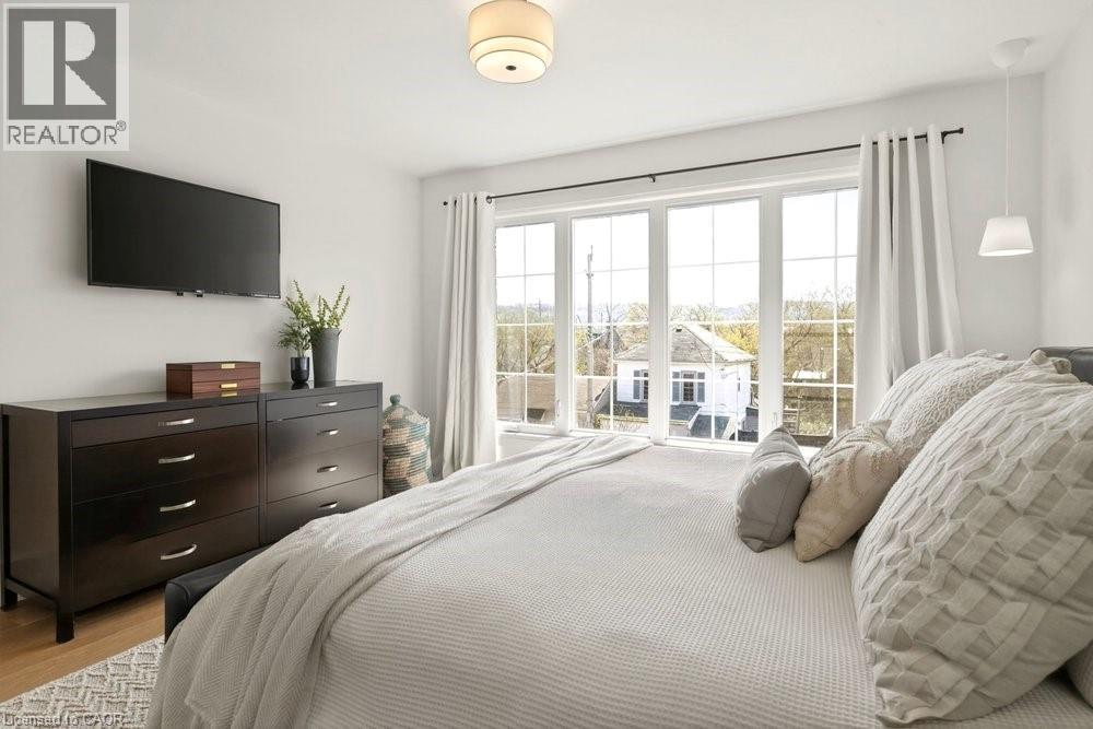 Expansive window wall with grid pattern, overhead flush mount light fixture, and wood-finish flooring