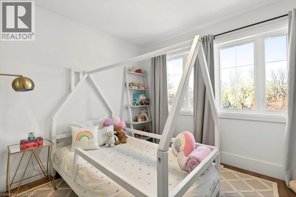 Bright room featuring two large windows, white walls, and wood-finish flooring